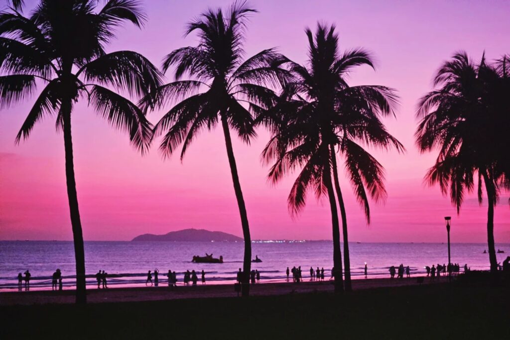 Coucher de soleil doré sur la promenade de 椰梦长廊 avec cocotiers le long de Sanya Bay