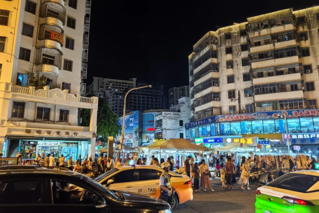 Scène animée d’un night market de Sanya, stands de street-food et ambiance chaleureuse.