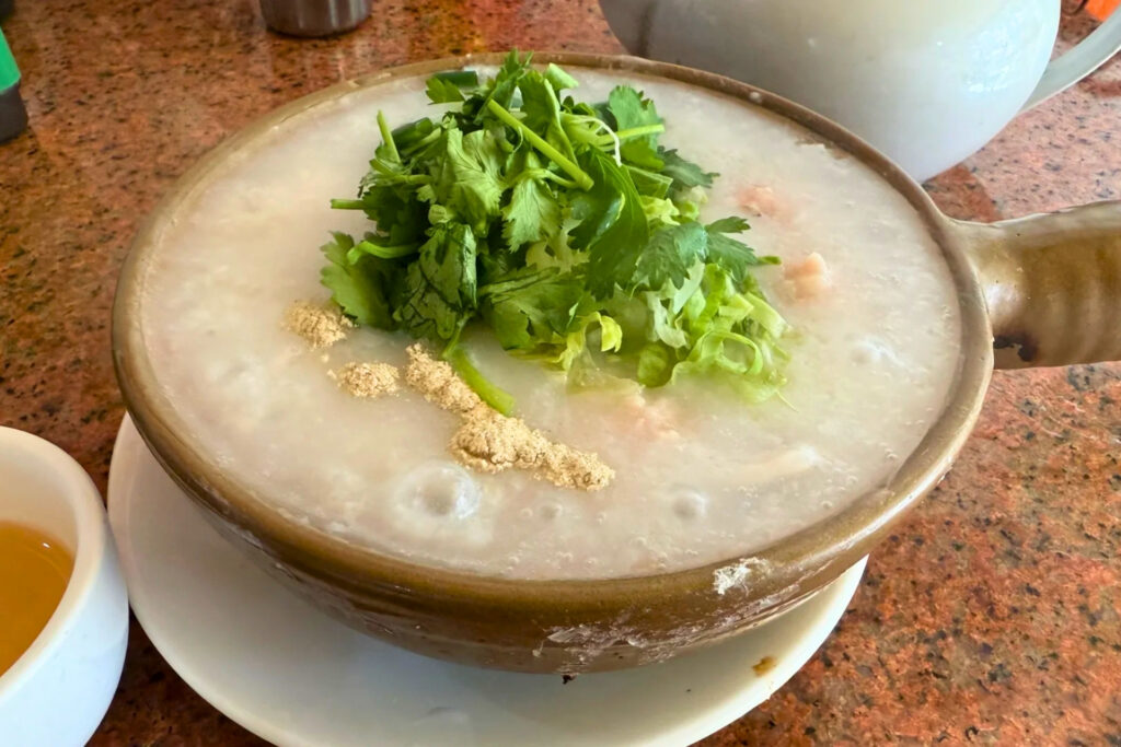 Bol de congee chinois à Shenzhen avec riz longuement cuit et garnitures locales, plat léger mangé tard le soir
