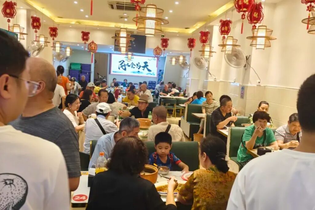 Client observant les plats commandés par les autres dans un restaurant chinois avant de choisir
