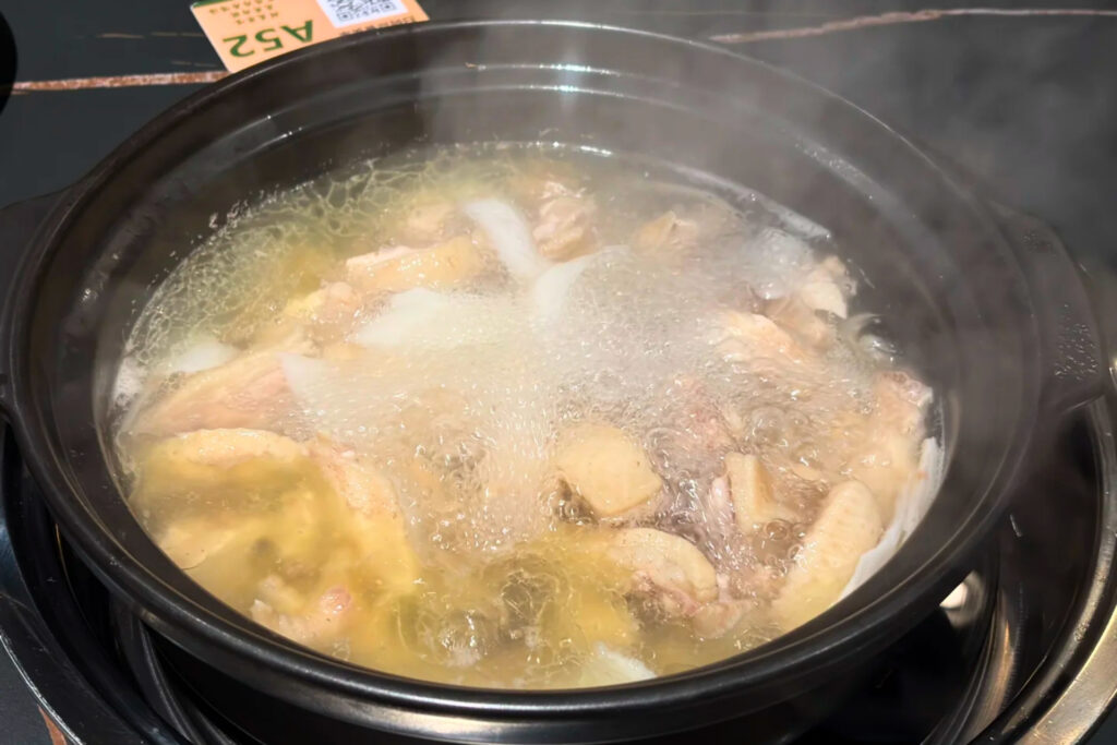 Poulet au coco yē zi jī à Shenzhen, bouillon clair et légèrement sucré à base de noix de coco fraîche, plat apprécié pour sa légèreté et sa digestibilité
