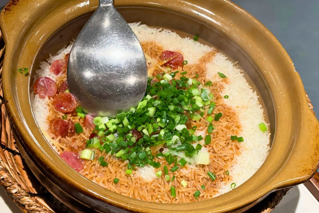 Riz en marmite bāo zǎi fàn à Shenzhen, grains séparés avec croûte dorée au fond et garnitures cantonaises, plat chaud mangé surtout le soir