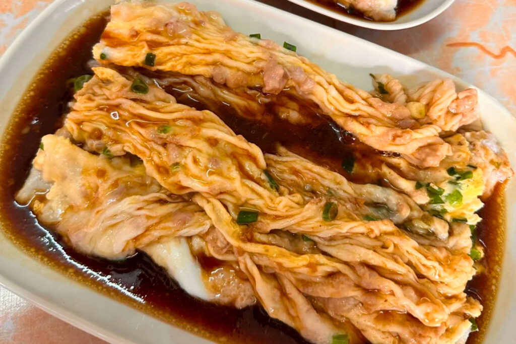 Rouleaux de riz vapeur cantonais cháng fěn servis à Shenzhen, texture fine et souple nappée de sauce soja légère, plat du quotidien mangé par les habitants