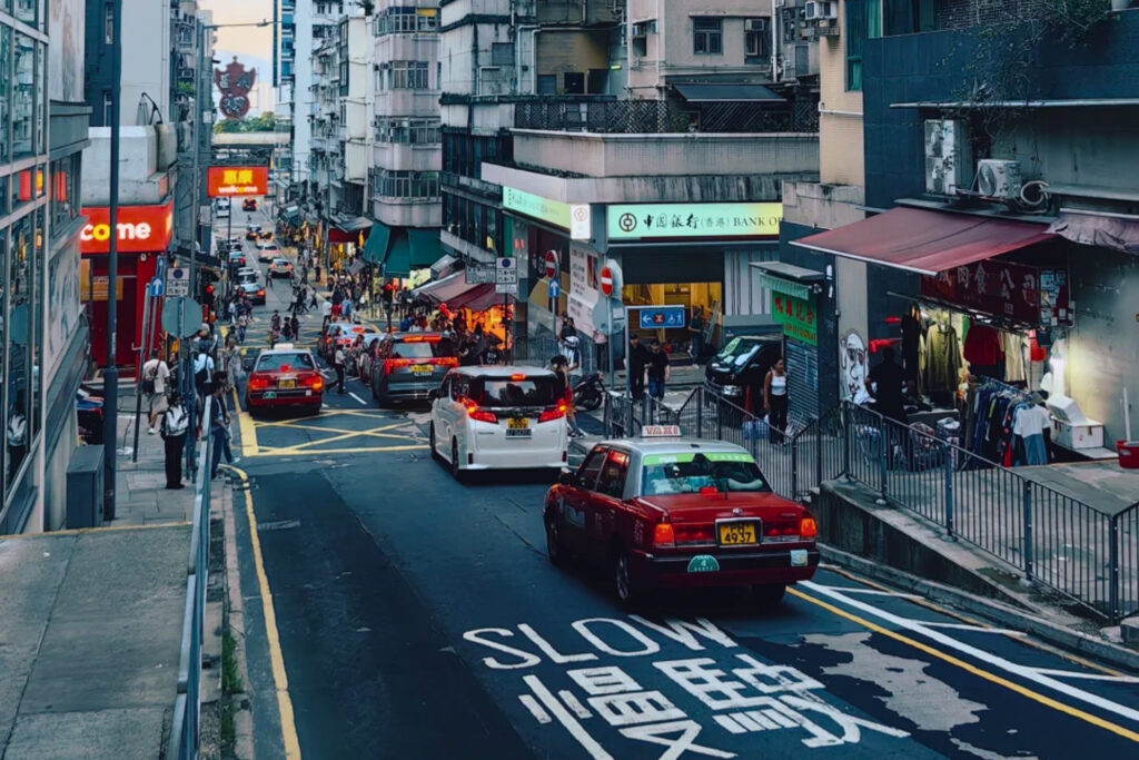 Rue en pente à Hong Kong illustrant la verticalité et la complexité des déplacements