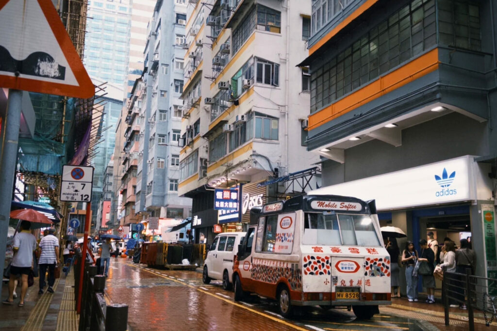 Sortie de station de métro à Hong Kong avec passerelles et circulation dense