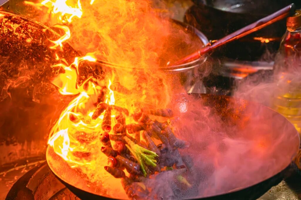 Cuisinier préparant de la street food au wok dans une rue de Shenzhen